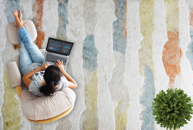 Area rug with tans, sage green and off white running through it.