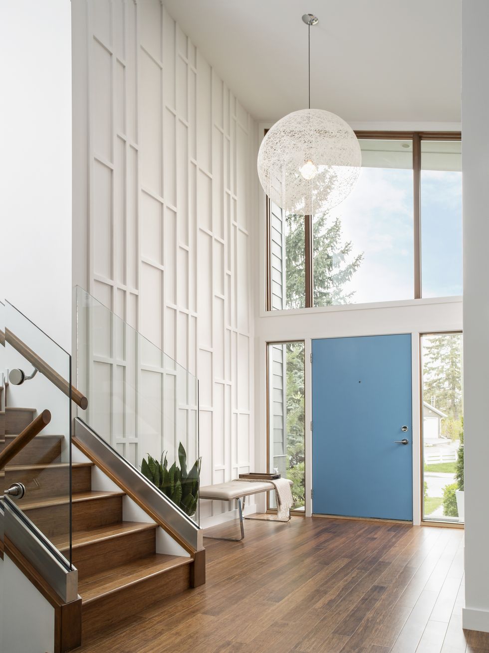 open foyer with large windows and blue door.